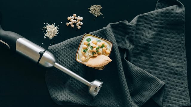 Delicious Mediterranean hummus with chickpeas and pita, styled in a modern flat lay.