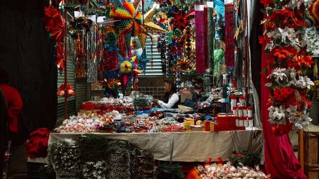 Colorful Christmas decorations at a market stall in Mexico City, CDMX, with festive lights and ornaments.