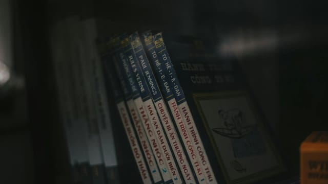 Close-up of books on a shelf in a dimly lit indoor setting. Ideal for educational themes.
