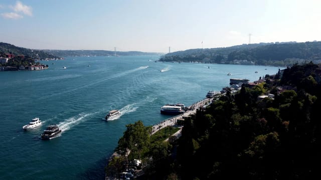 Aerial view of boats navigating the scenic Bosphorus Strait in Istanbul under a clear sky.