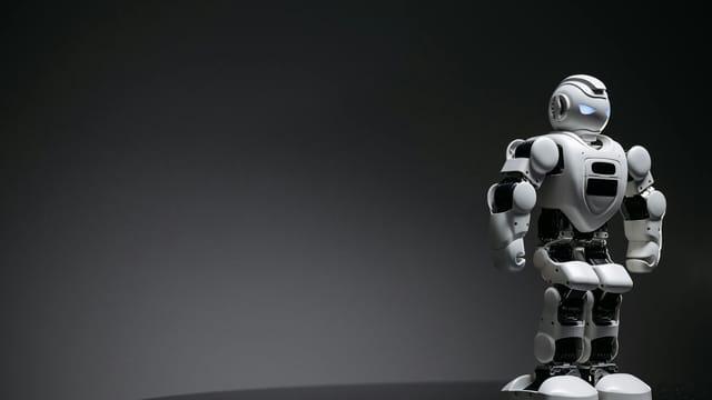 Compact humanoid robot toy standing on a reflective surface, exuding a futuristic vibe.