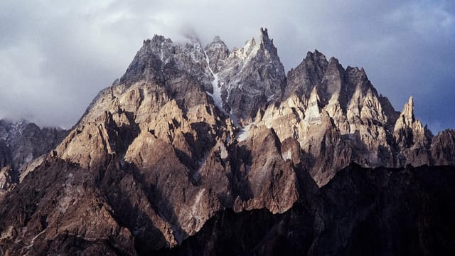 A stunning view of the rocky peaks of the Karakoram Range in Pakistan, captured at sunrise.