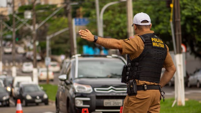 Police officer directing traffic on a busy street in Londrina, Brazil.