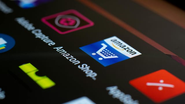 Close-up of the Amazon shopping app icon on a smartphone screen. Ideal for online shopping and technology themes.