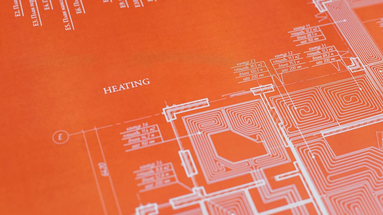Close-up of an orange architectural heating blueprint showing intricate design details.