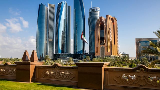 Stunning view of Abu Dhabi's Etihad Towers and city skyline under clear blue sky.