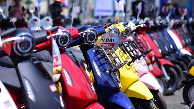 Vibrant lineup of scooters displayed outdoors, showcasing diverse colors and styles.