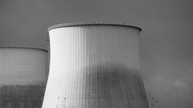 Elegant black and white depiction of cooling towers at a nuclear power station, symbolizing energy and industry.