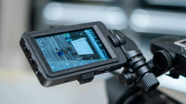 Close-up view of a camera monitor displaying captured footage with detailed settings.