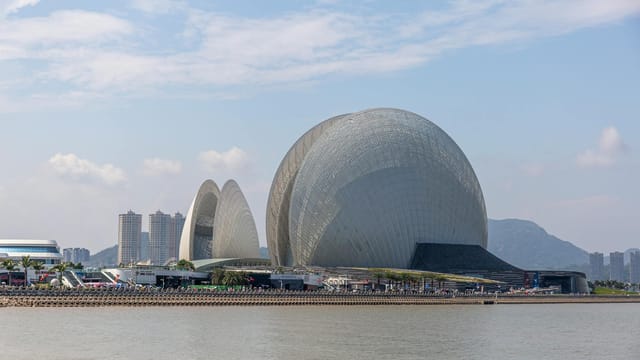 Stunning view of Zhuhai Opera House on a sunny day by the coastline.