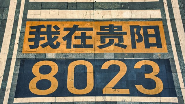 High angle view of street markings with Asian script and number 8023 in vibrant colors.