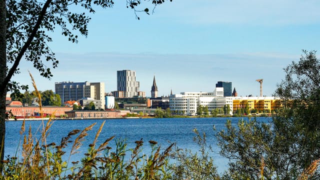 Beautiful view of Jönköping skyline with modern buildings by the lake under a blue sky.