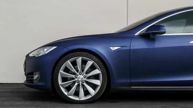 Navy blue electric vehicle showcasing sleek design and front wheel close-up.