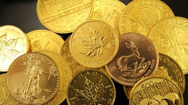 A detailed close-up of diverse gold bullion coins from different countries.