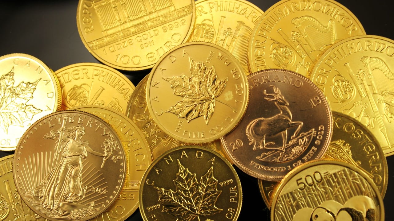 A detailed close-up of diverse gold bullion coins from different countries.