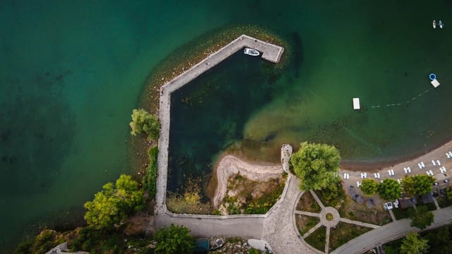 A breathtaking aerial shot of a dock and green waters of Lake Ohrid, North Macedonia.