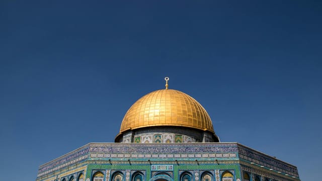 The stunning Dome of the Rock with its golden dome under a clear blue sky in Jerusalem.
