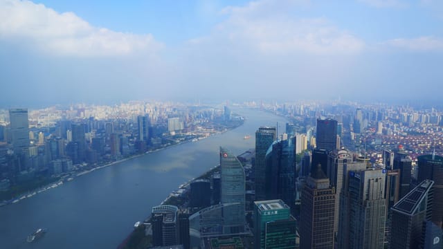 A breathtaking aerial cityscape of Shanghai, China, featuring skyscrapers along the Huangpu River.