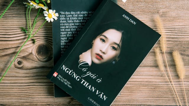 Vietnamese book cover shot in a flat lay showing elegant modern design on wooden backdrop.