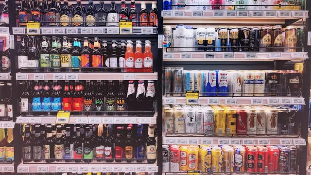 Wide variety of bottled and canned beers displayed on store shelves in Shanghai, China.