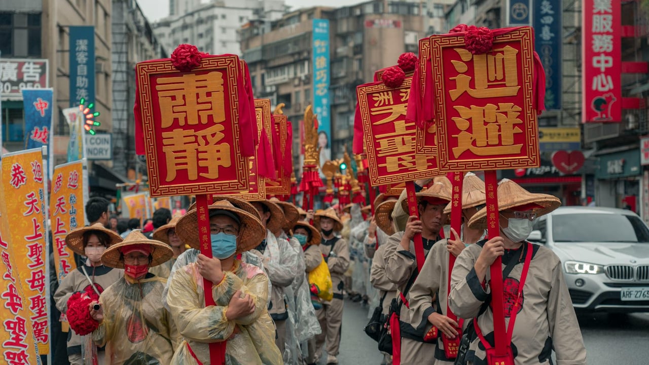 Vibrant street parade showcasing Asian cultural heritage with banners and traditional costumes.