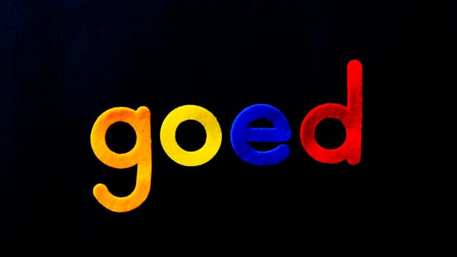 Vibrant letters spelling 'goed' against a dark backdrop, highlighting typography.
