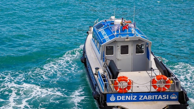 Marine patrol boat cruising the vibrant waters of Istanbul, Turkey with clear blue sea and lifebuoys onboard.