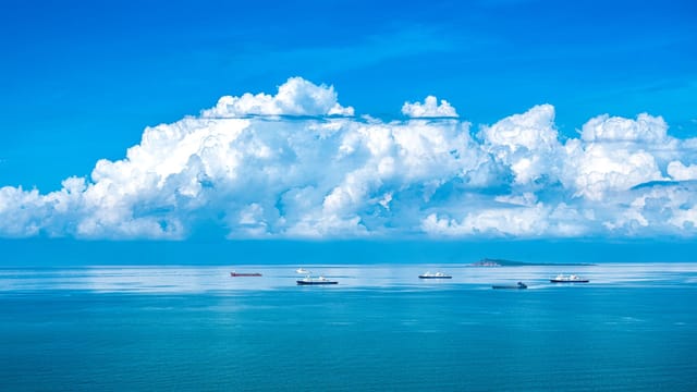 Beautiful ocean view with ships under white clouds in Sanya, Hainan, China.