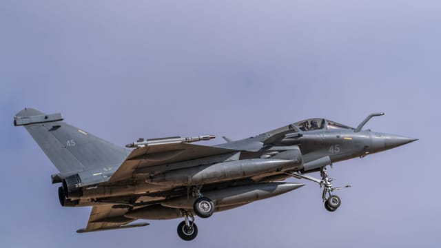 A Dassault Rafale jet captured in mid-air against a clear sky at Los Llanos, Spain.