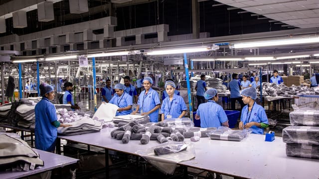 Indian textile factory workers expertly packaging products on an assembly line.