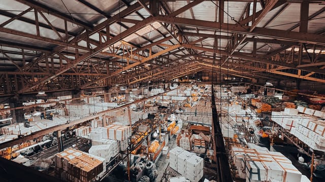 An aerial view of a vibrant indoor market with stalls in Bangkok, Thailand.