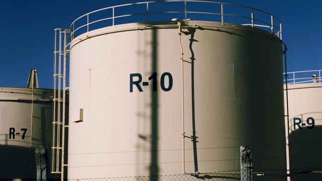 Large industrial storage tanks under blue skies, highlighting metal structures.