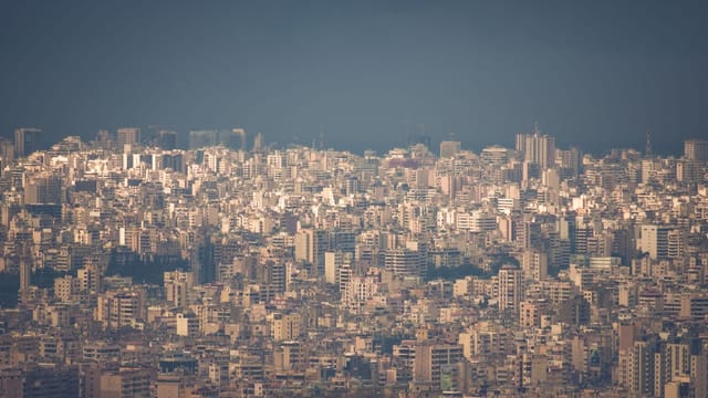 A sprawling view of Beirut's densely packed buildings under a foggy sky, highlighting urban density.