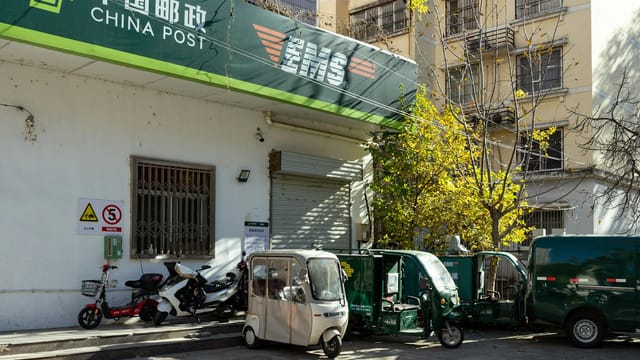 China Post office facade with delivery vehicles in Luoyang, Henan, China.