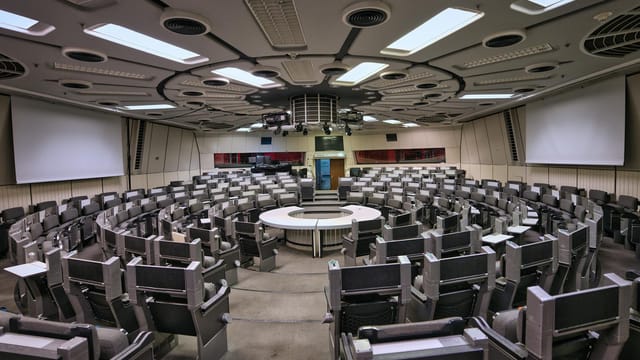 Empty futuristic conference room in Berlin ICC with circular seating and high-tech design.