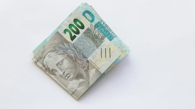 Stack of 200 Brazilian Real banknotes isolated on a white surface, symbolizing wealth and finance.
