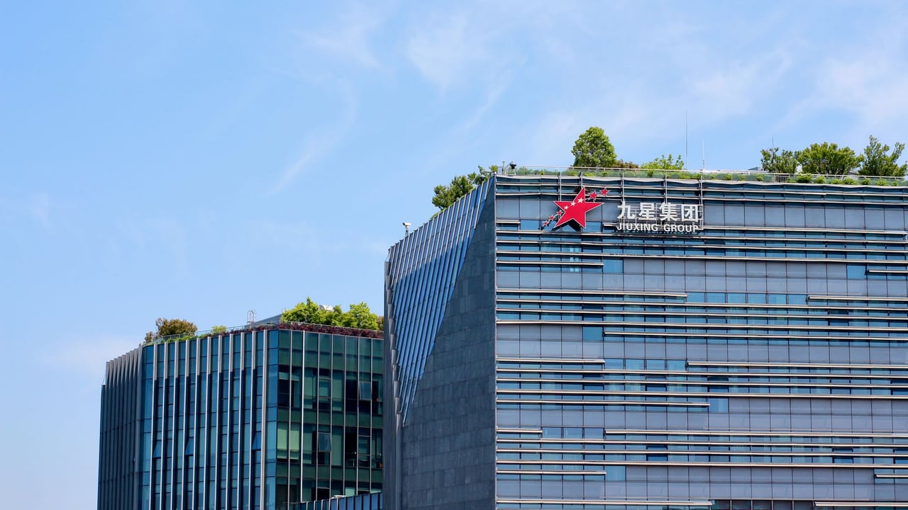 Contemporary corporate building featuring green rooftop and modern architecture against blue sky.