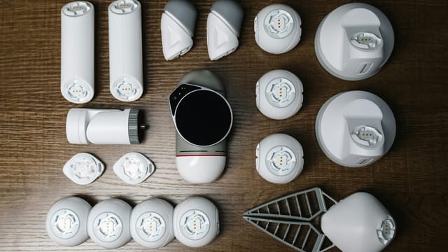 Assorted robotics parts arranged neatly on a wooden surface, showcasing innovative technology.