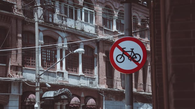 Street scene featuring a no bicycle sign against a backdrop of vintage architecture.