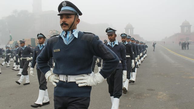 Indian soldiers in uniform marching during a foggy parade ceremony.