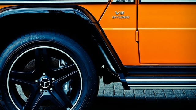 Detailed view of a luxury SUV's wheel and tire, showcasing design elements.