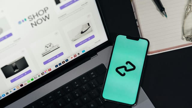 A smartphone and laptop displaying online shopping platforms, suggesting digital retail.