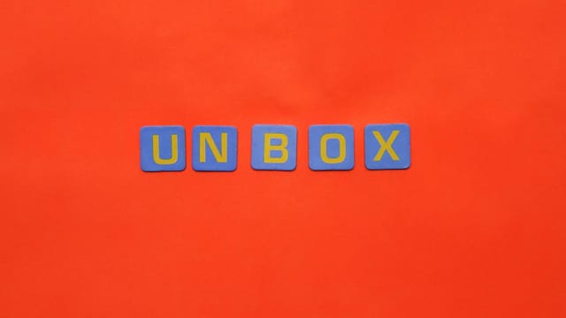 Bright letters spelling 'unbox' on a vivid red background, minimalist design.