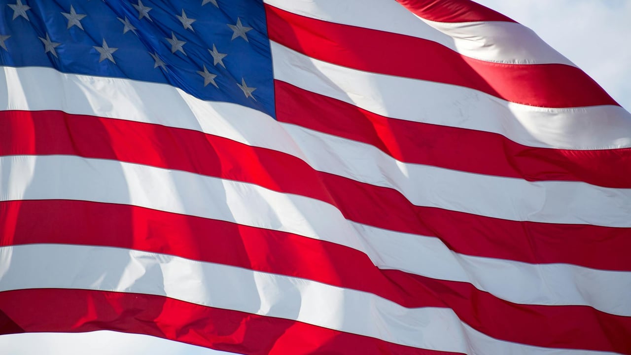 Close-up of the USA flag waving in the wind, symbolizing patriotism and freedom.