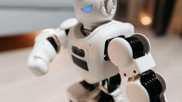 Close-up of a futuristic toy robot with blue eyes, showcasing modern technology indoors.