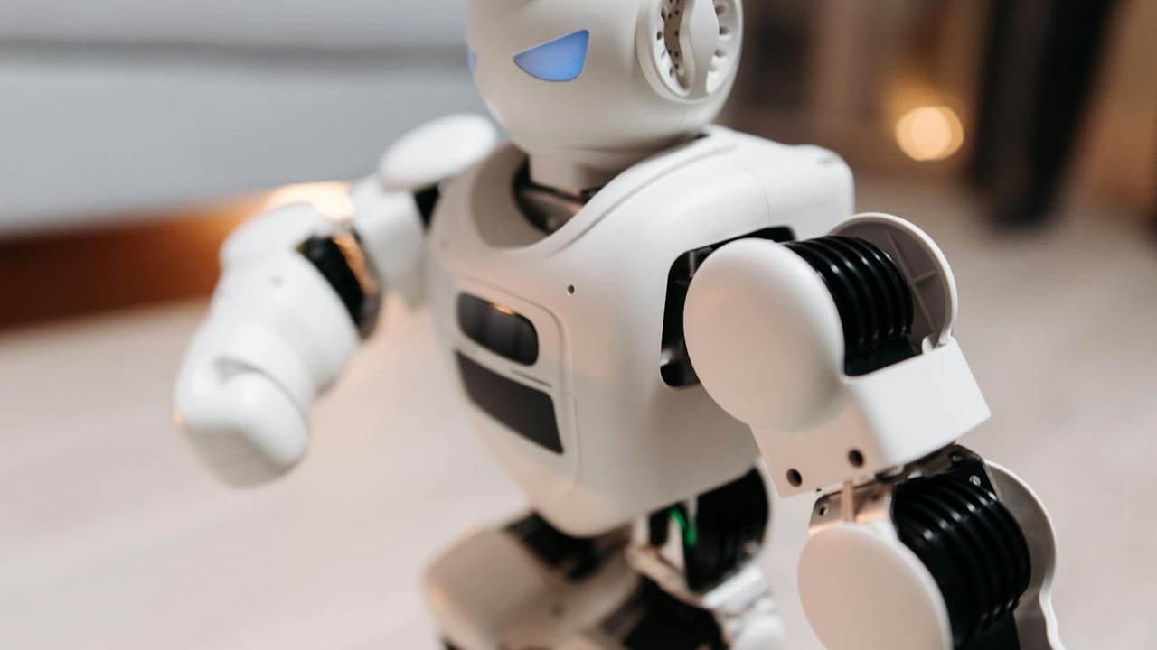 Close-up of a futuristic toy robot with blue eyes, showcasing modern technology indoors.
