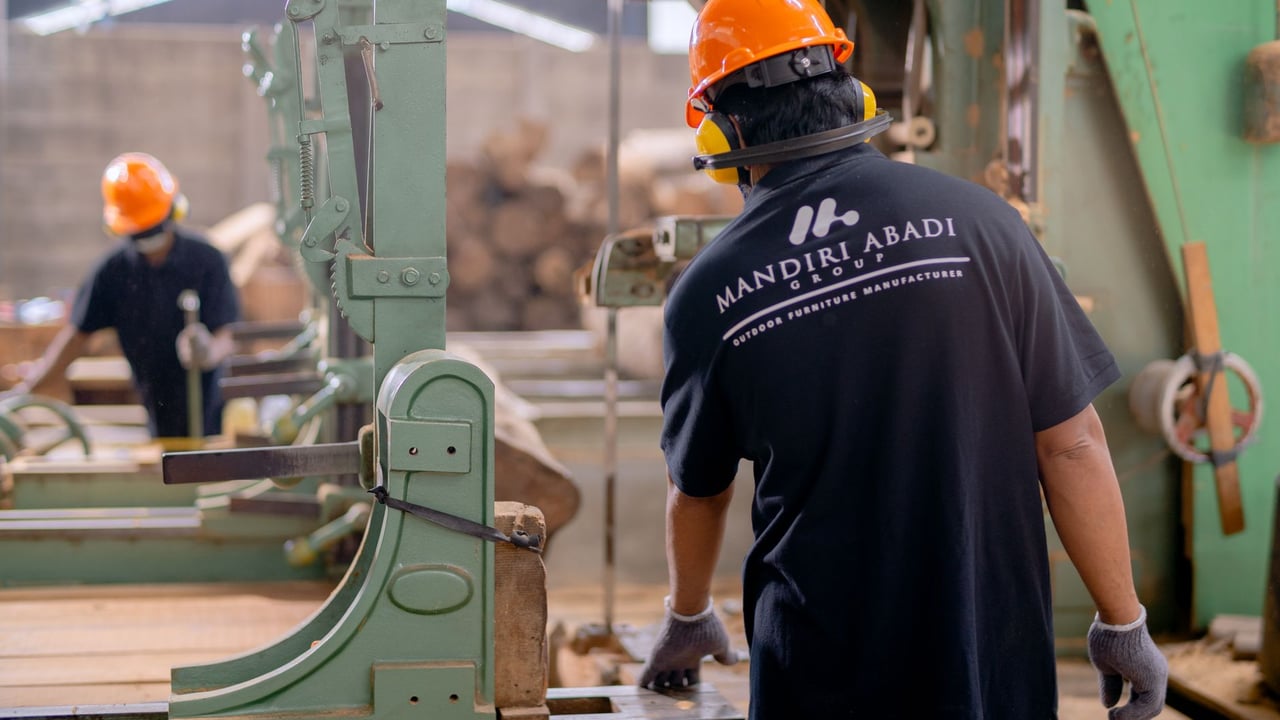 Illustrative image: Workers wearing protective gear operating machinery in a factory environment, focusing on safety and production.