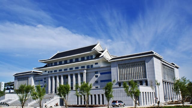 A contemporary building showcasing Asian architecture under a clear blue sky, outdoors.