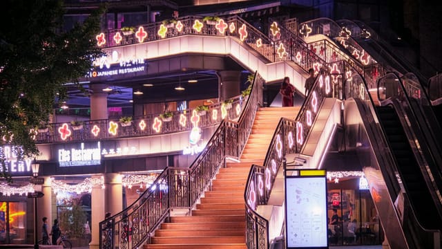 Colorful illuminated staircase in a lively Shanghai outdoor setting at night.