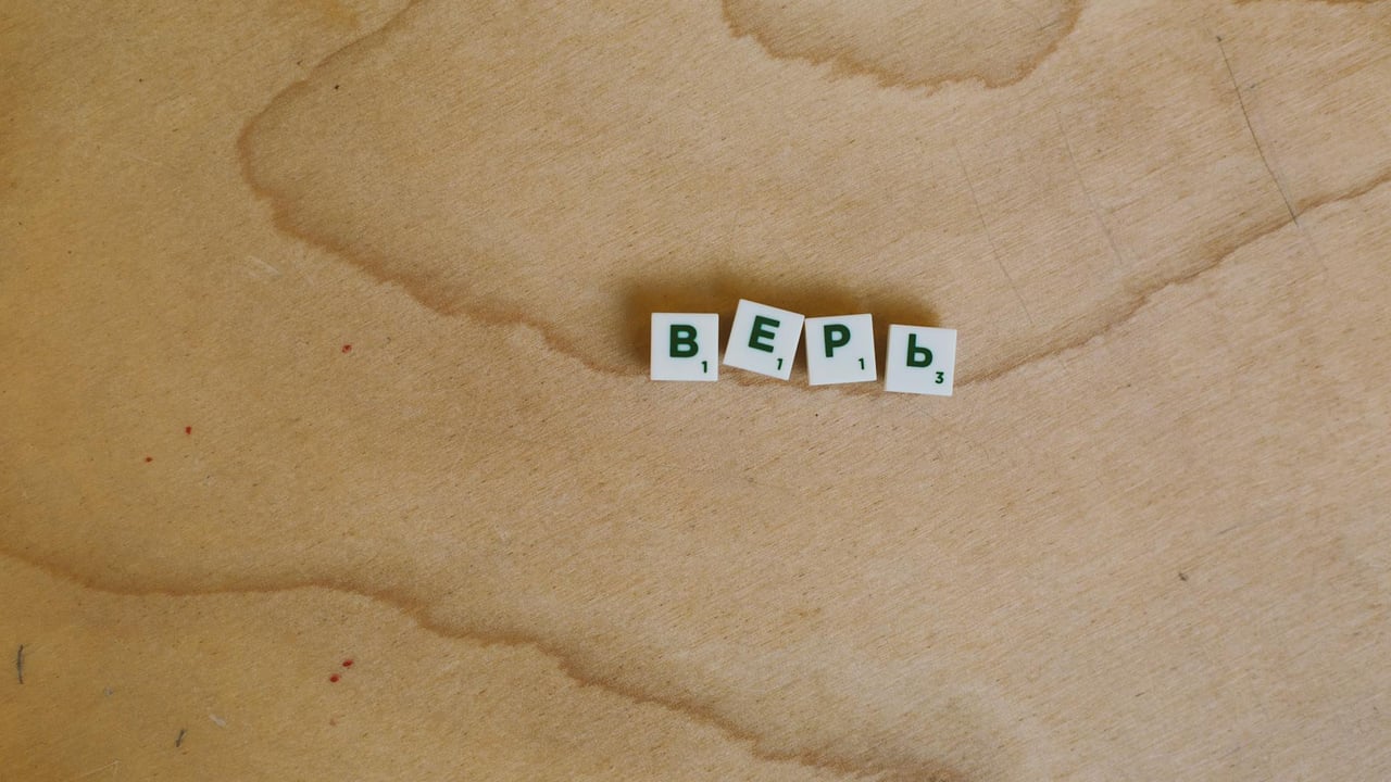 Scrabble tiles with Cyrillic letters spelling 'верь' displayed on a wooden surface.